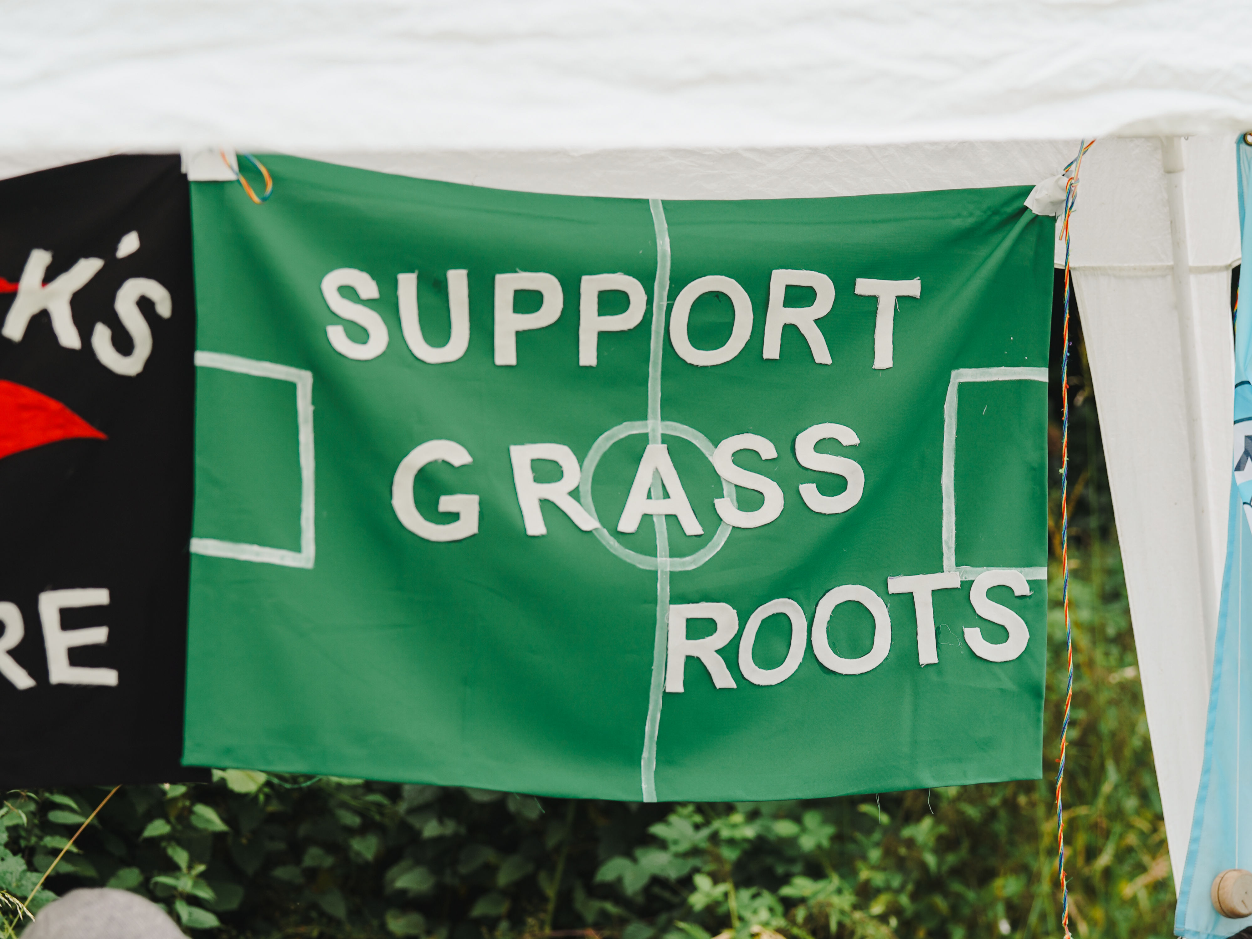 A green banner with 'Support Grass Roots' in white text